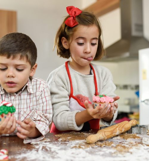 Children eating Christmas cookies and cup cakes